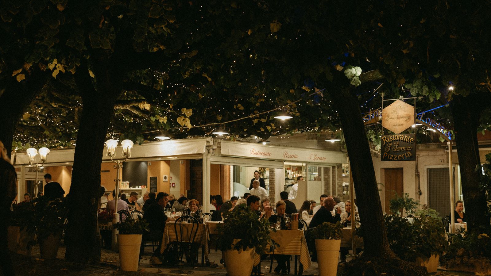 Diners in a restaurant courtyard at night
